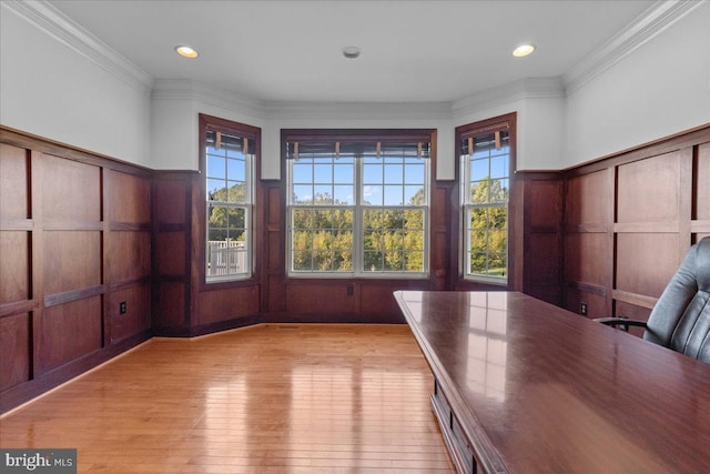 unfurnished office featuring light wood-type flooring and crown molding