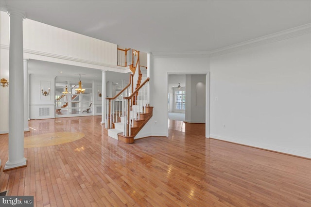 spare room featuring ornamental molding, decorative columns, and hardwood / wood-style floors