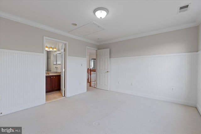 interior space with ornamental molding, ensuite bath, light carpet, and sink