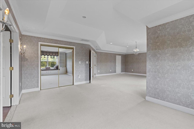 interior space featuring carpet floors, a tray ceiling, a chandelier, and ornamental molding