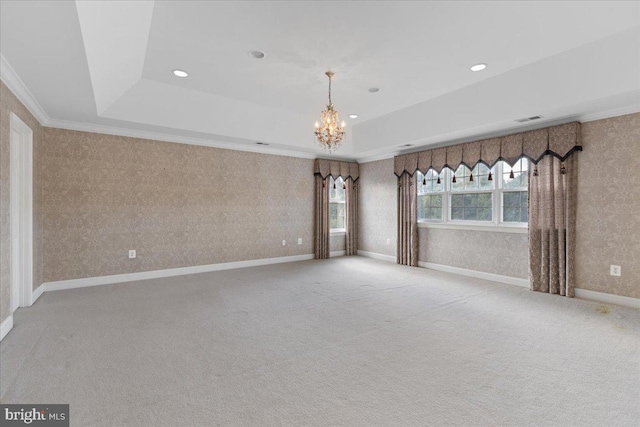 carpeted spare room featuring a chandelier, a tray ceiling, and crown molding