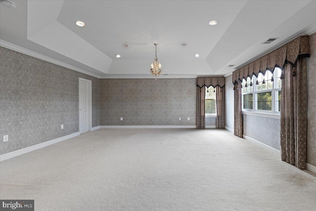 carpeted spare room featuring a raised ceiling, crown molding, and a notable chandelier