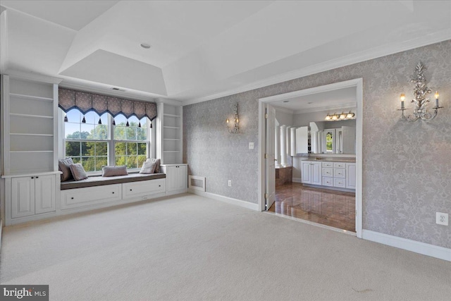 interior space featuring ornamental molding, a raised ceiling, a chandelier, and carpet flooring