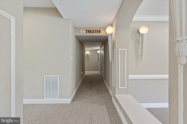 corridor featuring ornamental molding and carpet flooring