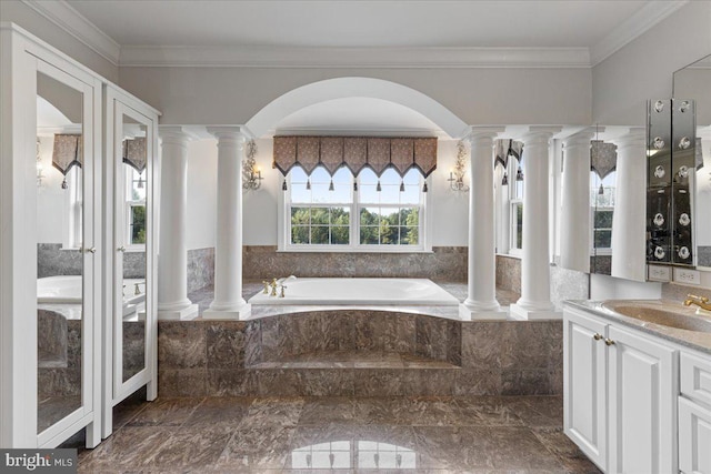 bathroom with decorative columns, tiled bath, vanity, and ornamental molding