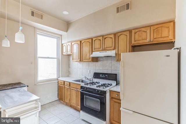 kitchen featuring tasteful backsplash, white appliances, light tile patterned floors, pendant lighting, and sink