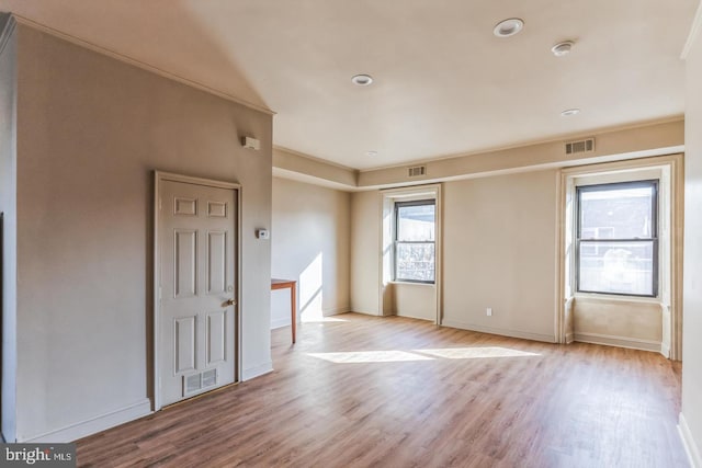 unfurnished room featuring light wood-type flooring and crown molding