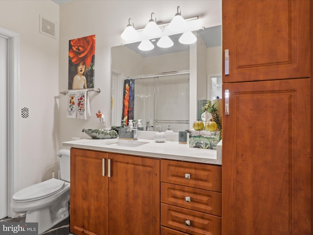 bathroom featuring vanity, toilet, and a shower with door