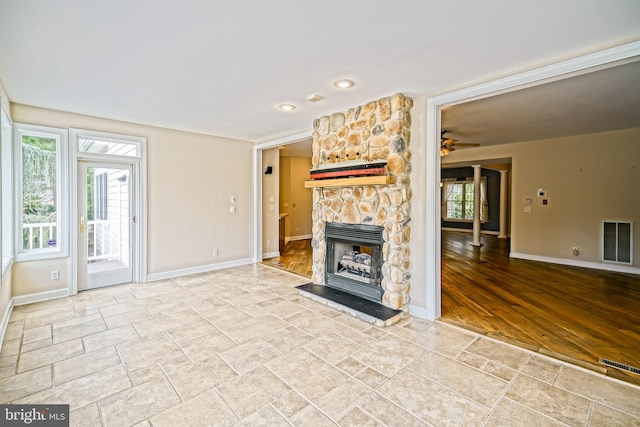 unfurnished living room with plenty of natural light, light hardwood / wood-style floors, a fireplace, and ceiling fan