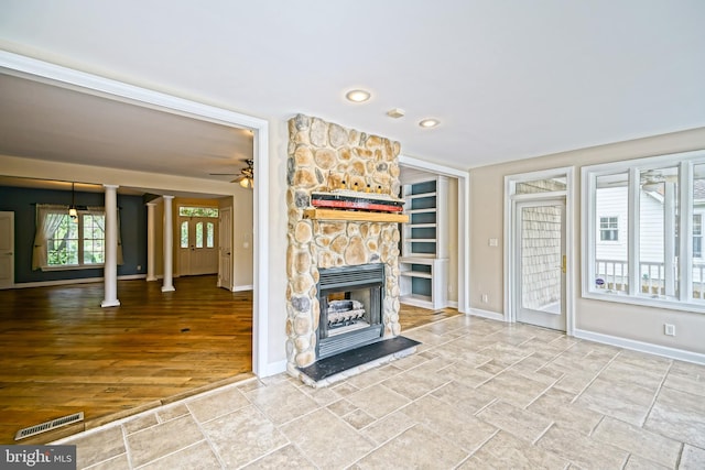 unfurnished living room with built in shelves, ceiling fan, a fireplace, and hardwood / wood-style floors