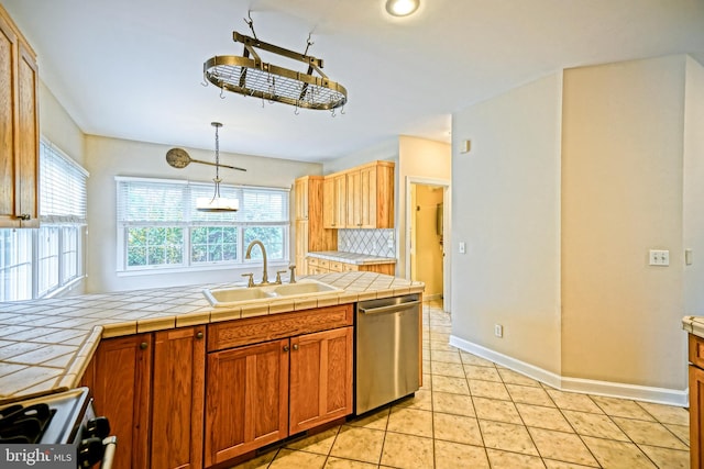 kitchen with sink, decorative light fixtures, dishwasher, tile countertops, and white gas stove