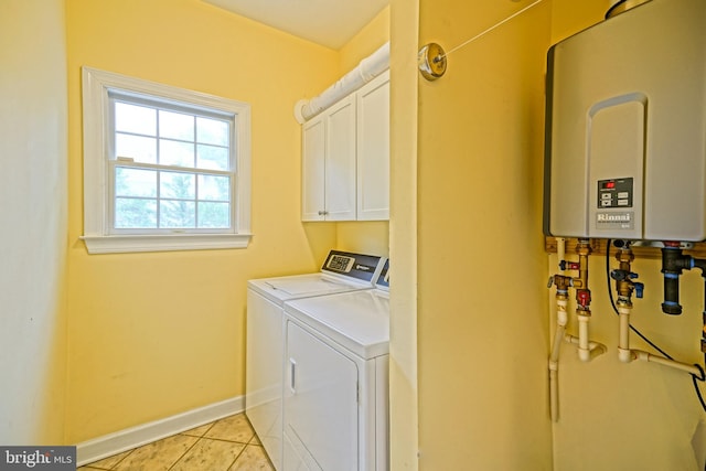 laundry room with cabinets, water heater, light tile patterned floors, and washer and dryer