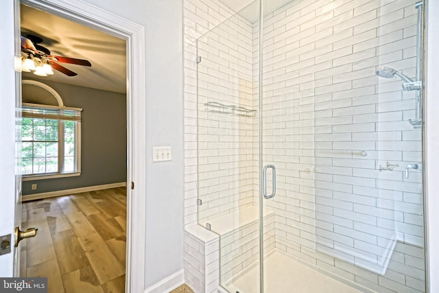 bathroom with ceiling fan, hardwood / wood-style floors, and an enclosed shower