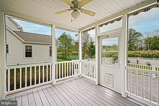 unfurnished sunroom with ceiling fan