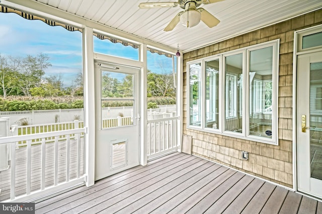 unfurnished sunroom with ceiling fan