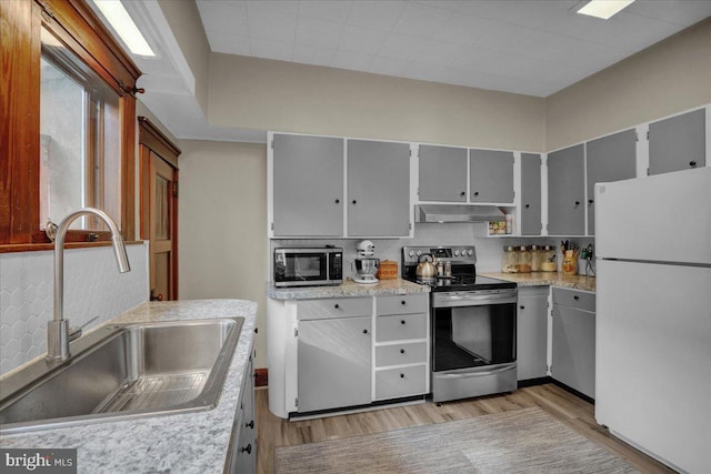 kitchen with light hardwood / wood-style flooring, appliances with stainless steel finishes, tasteful backsplash, and sink