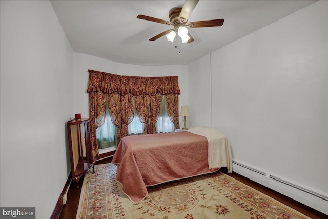 bedroom featuring ceiling fan, a baseboard heating unit, and hardwood / wood-style flooring