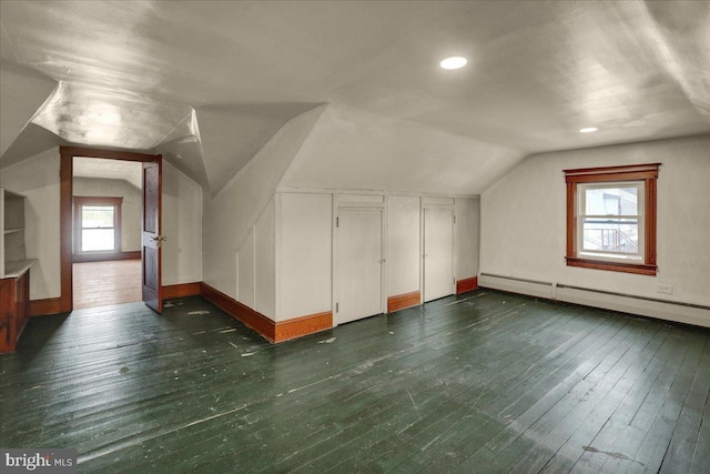 additional living space with vaulted ceiling, baseboard heating, and dark hardwood / wood-style floors