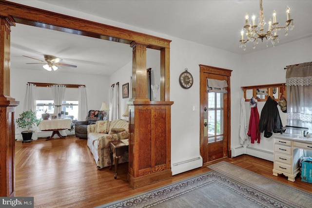 foyer entrance featuring ceiling fan with notable chandelier, wood-type flooring, and a baseboard radiator