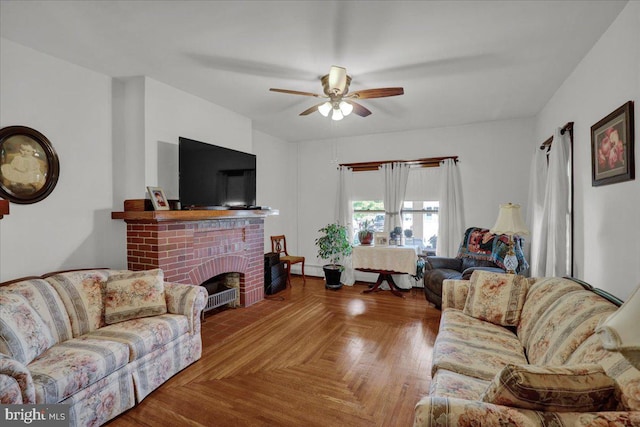 living room with light parquet flooring, ceiling fan, and a brick fireplace