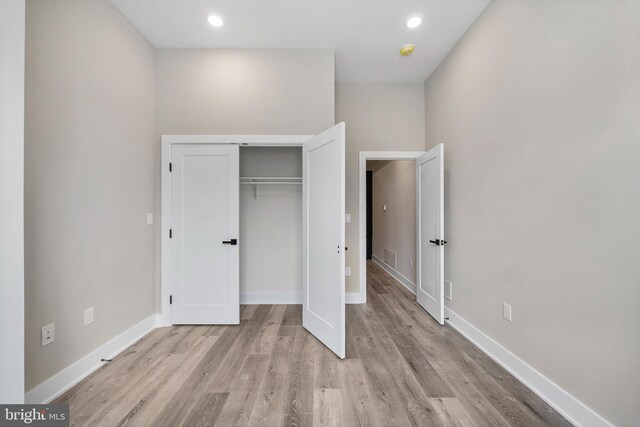 unfurnished bedroom featuring light hardwood / wood-style flooring and a closet