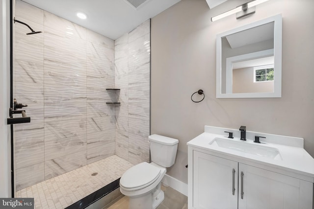 bathroom with vanity, tile patterned floors, toilet, and tiled shower