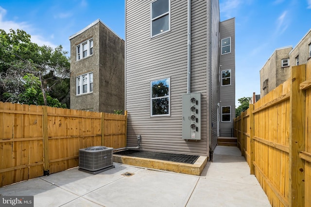 rear view of property featuring a patio and central air condition unit