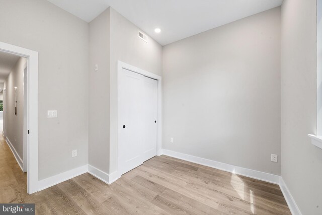 unfurnished bedroom featuring a closet and light hardwood / wood-style floors