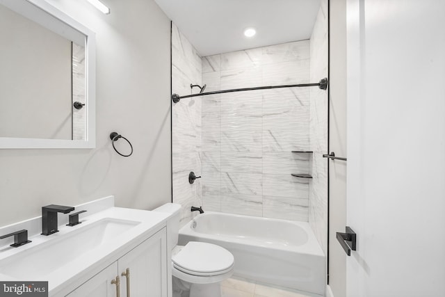 full bathroom featuring tile patterned flooring, tiled shower / bath combo, vanity, and toilet