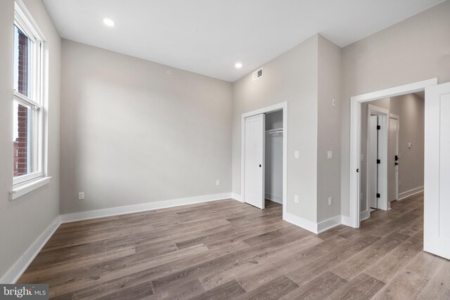 unfurnished bedroom featuring light hardwood / wood-style flooring and a closet