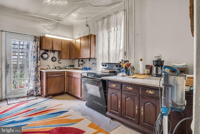 kitchen with black electric range oven and tasteful backsplash