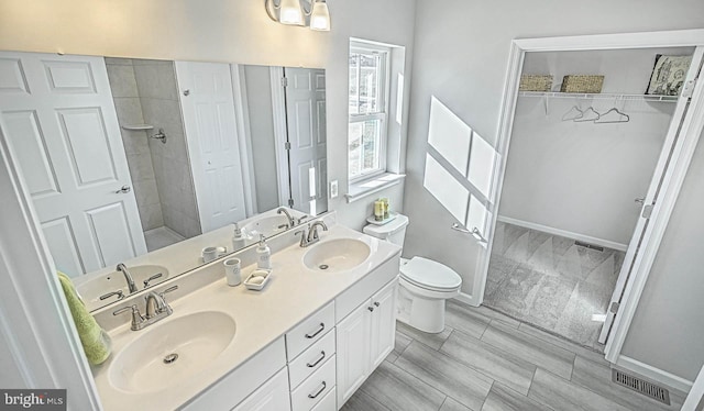 bathroom featuring vanity, toilet, and a shower