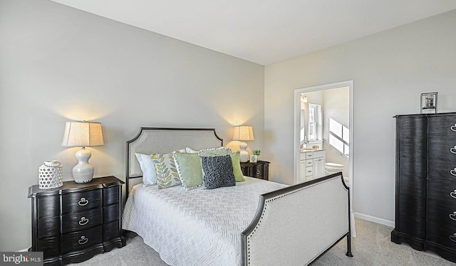 bedroom featuring light colored carpet and ensuite bath