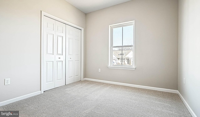 unfurnished bedroom featuring carpet and a closet