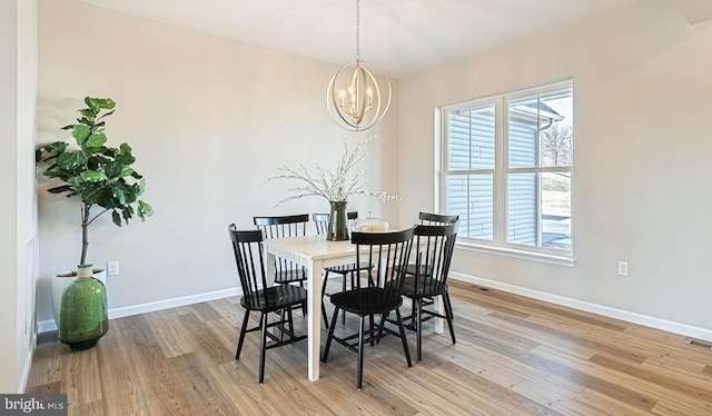 dining room featuring light hardwood / wood-style floors and a notable chandelier