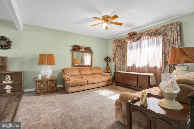 living room featuring a ceiling fan and baseboards