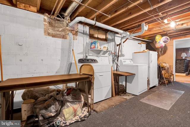 unfinished below grade area featuring freestanding refrigerator and washing machine and clothes dryer