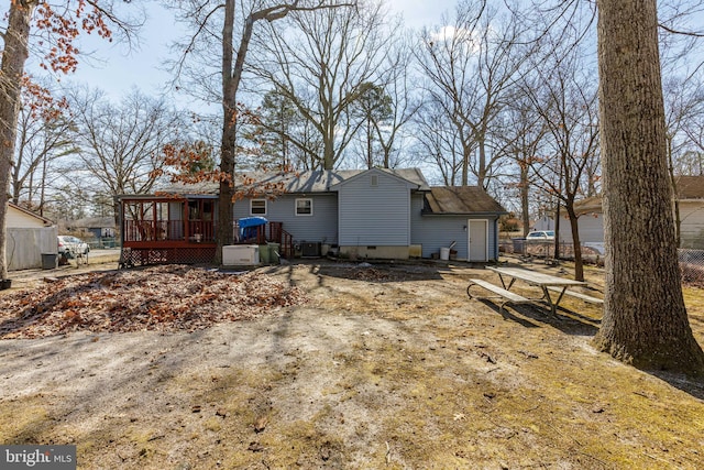 rear view of property with crawl space and a deck