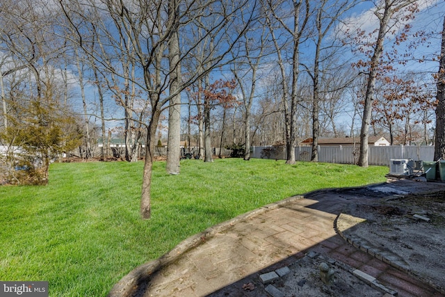 view of yard featuring central AC and fence