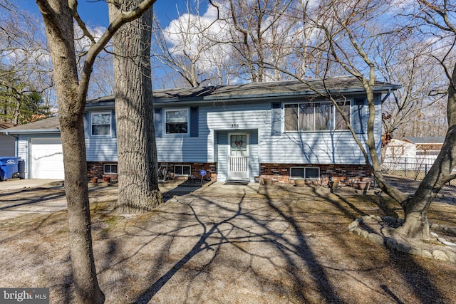 split foyer home featuring fence and an attached garage