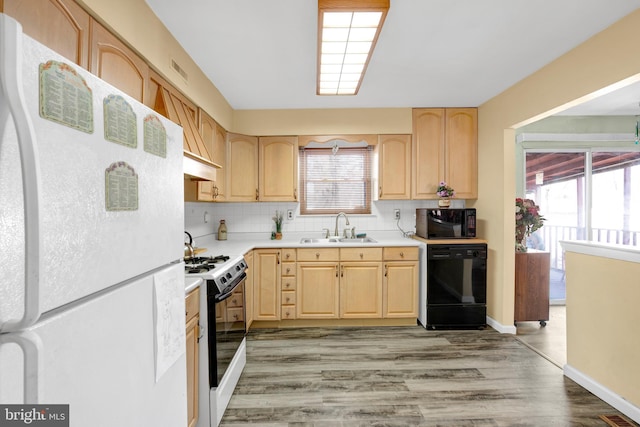 kitchen with a sink, light countertops, light brown cabinetry, black appliances, and tasteful backsplash