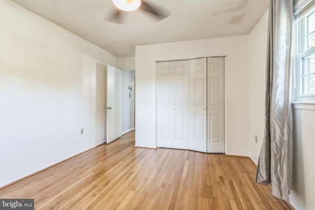 unfurnished bedroom featuring a closet, light wood-type flooring, and ceiling fan