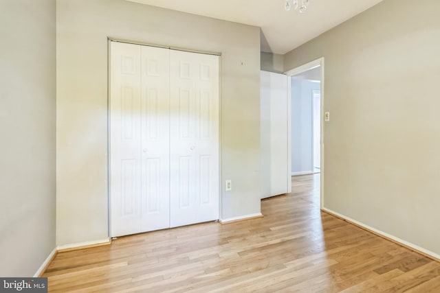 unfurnished bedroom with a closet and light hardwood / wood-style floors