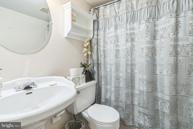 bathroom featuring sink, toilet, and a shower with curtain