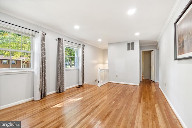 spare room featuring ornamental molding and light hardwood / wood-style floors