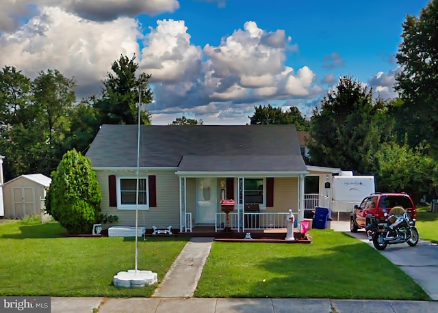 view of front of property with a storage unit, a front yard, and covered porch