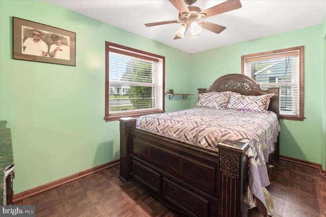 bedroom featuring ceiling fan, dark parquet floors, and multiple windows