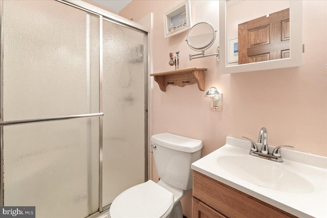 bathroom featuring vanity, toilet, and an enclosed shower