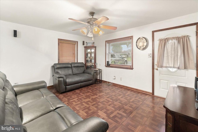 living room with ceiling fan and dark parquet floors