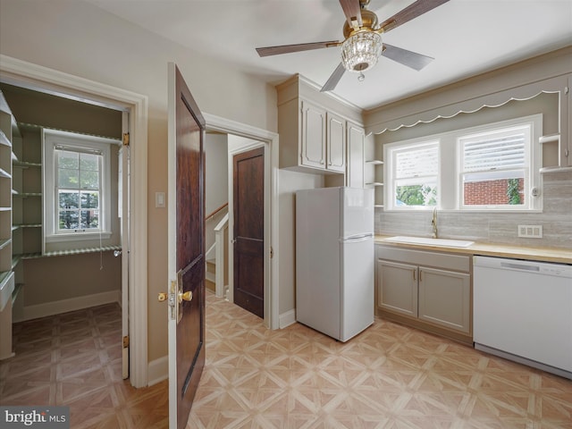 kitchen featuring white appliances, sink, ceiling fan, and plenty of natural light